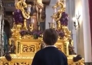 Un niño le canta a Cristo clavado en la Cruz